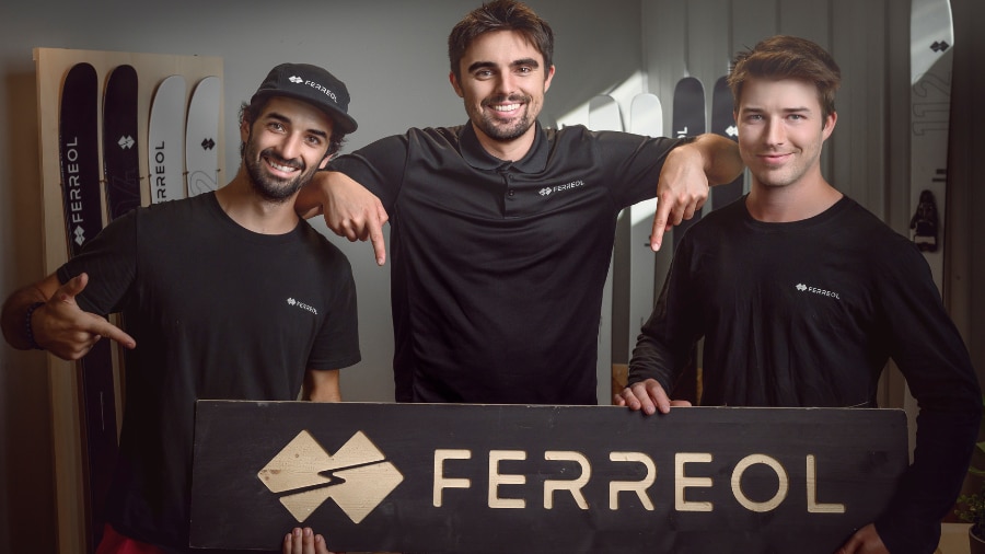 3 men holding a banner and smiling at the camera 